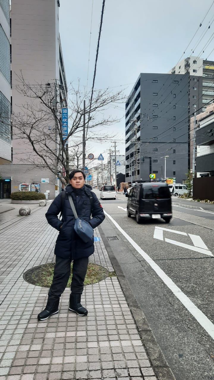 Mufli on a city street in Japan with a car in the background